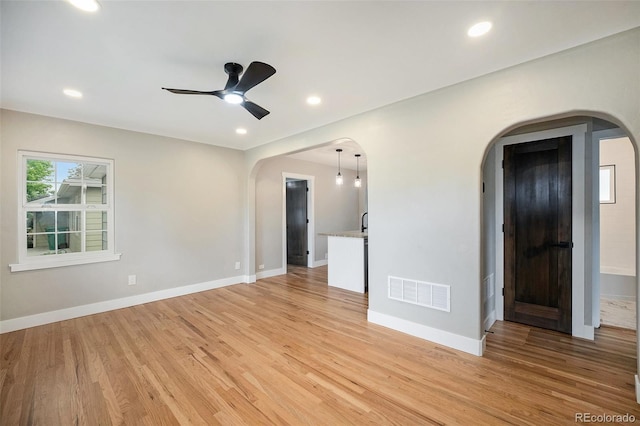 5100 Clay St, Denver, CO 80221 - empty room featuring arched walkways, light wood finished floors, a ceiling fan, baseboards, and recessed lighting