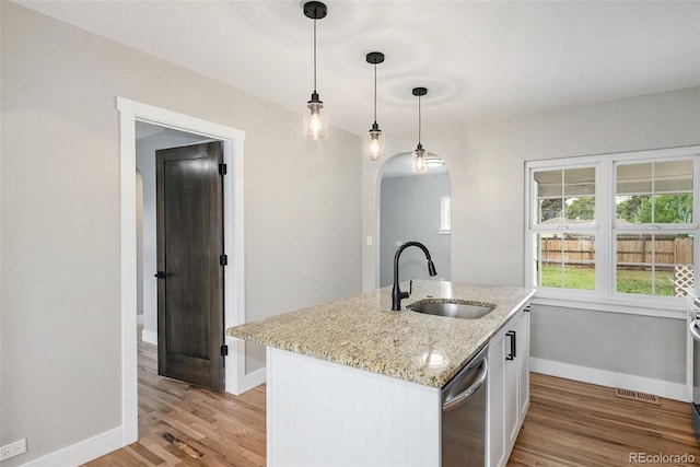 5100 Clay St, Denver, CO 80221 - kitchen featuring dishwasher, baseboards, a sink, arched walkways, and light wood finished floors