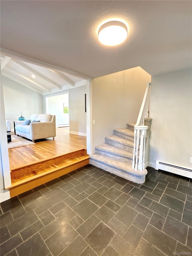 interior space featuring hardwood / wood-style floors, beamed ceiling, a baseboard radiator, and a textured ceiling