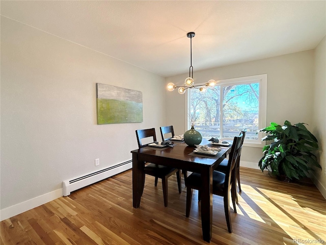 dining space featuring baseboard heating, a chandelier, and hardwood / wood-style flooring