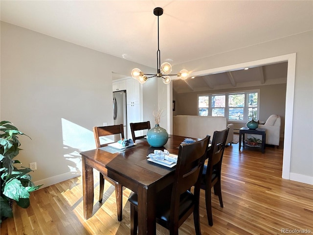 dining room featuring a chandelier, lofted ceiling with beams, and hardwood / wood-style flooring