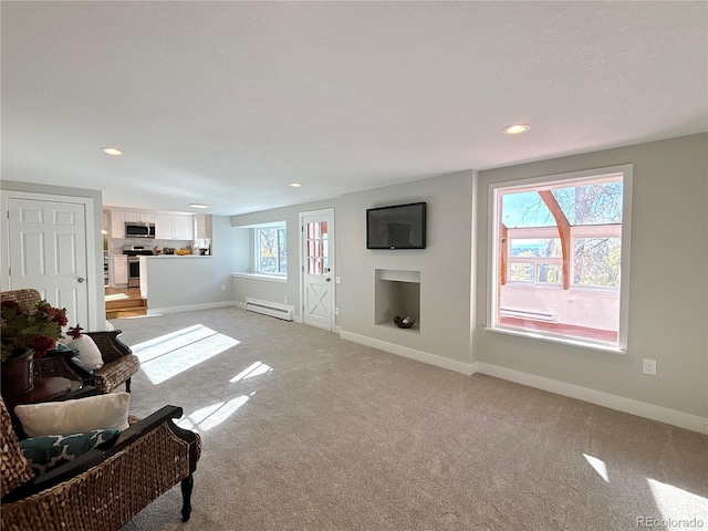 carpeted living room featuring plenty of natural light and a baseboard radiator