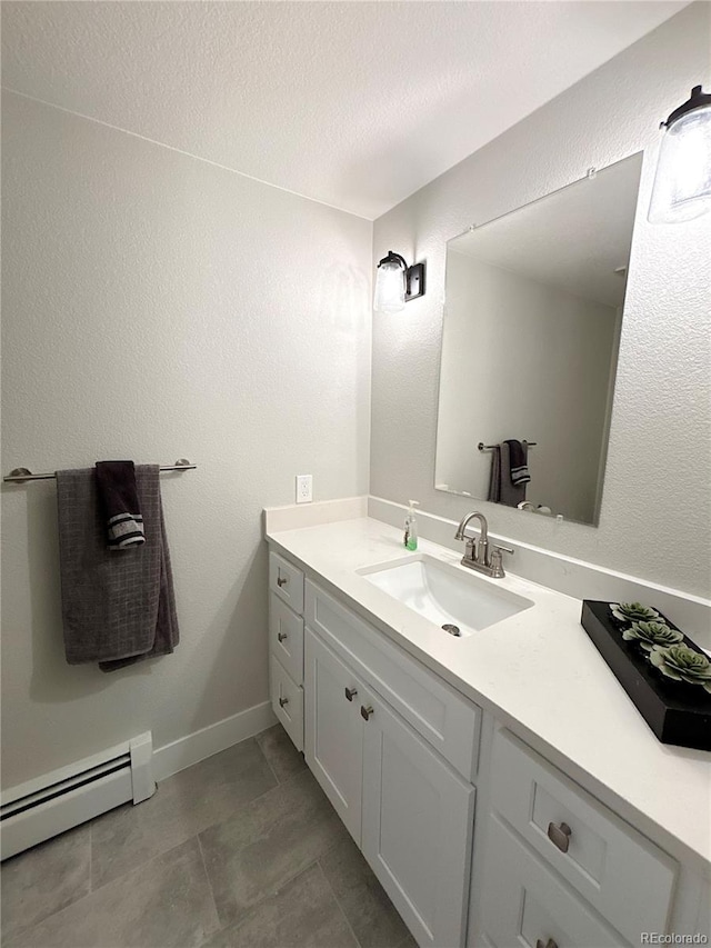 bathroom with tile patterned flooring, vanity, and a baseboard heating unit