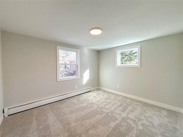 carpeted spare room featuring baseboard heating