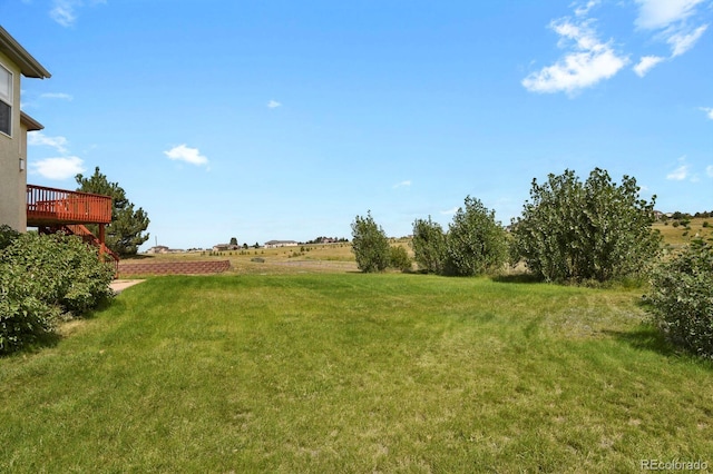 view of yard with a rural view and a deck