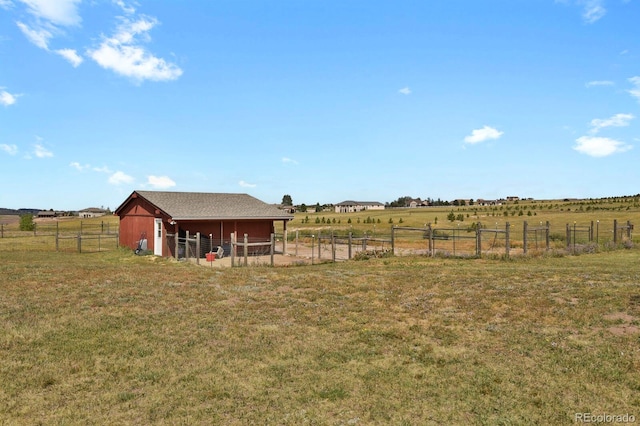 view of yard with an outbuilding and a rural view