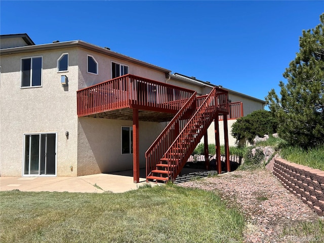 rear view of house with a patio area, a deck, and a yard