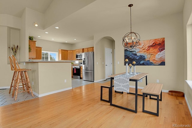 dining space with a chandelier and light hardwood / wood-style flooring