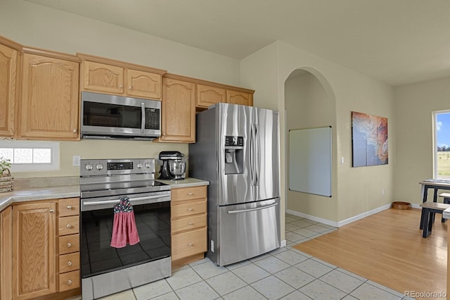 kitchen with light brown cabinetry, light hardwood / wood-style flooring, and appliances with stainless steel finishes