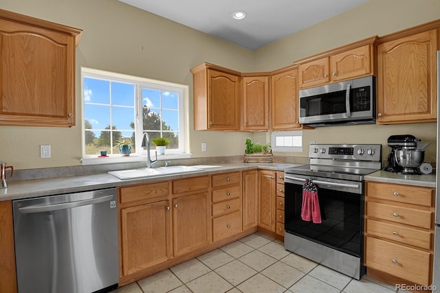 kitchen featuring light tile patterned floors, stainless steel appliances, and sink