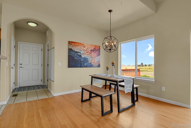 dining space featuring an inviting chandelier and light wood-type flooring