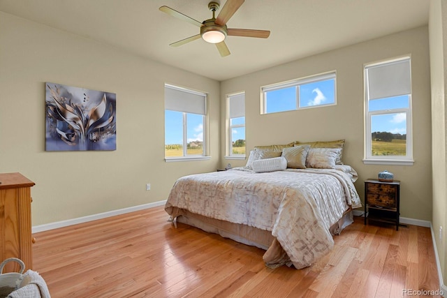 bedroom featuring multiple windows, ceiling fan, and light hardwood / wood-style floors