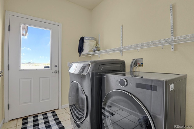 clothes washing area with light tile patterned floors and independent washer and dryer