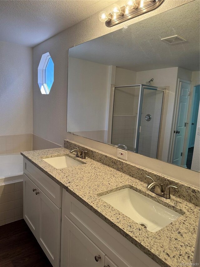 13959 Eudora St, Thornton, CO 80602 - bathroom with a textured ceiling, a stall shower, double vanity, a bath, and wood finished floors
