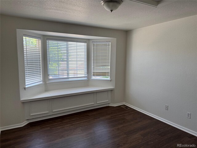 13959 Eudora St, Thornton, CO 80602 - unfurnished room featuring dark wood-style flooring, baseboards, and a textured ceiling