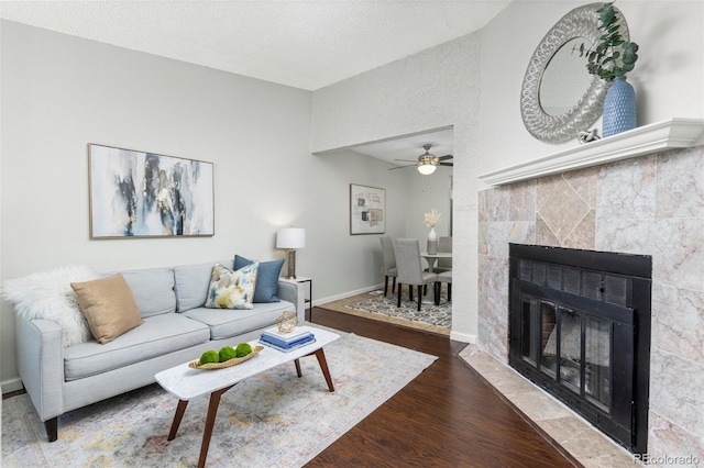 8260 Washington St Unit 78, Denver, CO 80229 - living area featuring wood finished floors, a ceiling fan, and a tiled fireplace