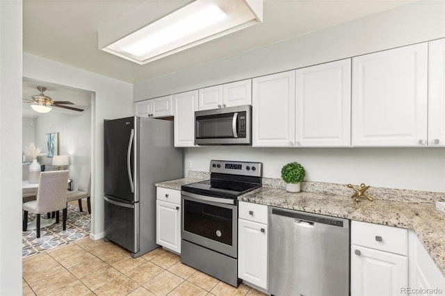 8260 Washington St Unit 78, Denver, CO 80229 - kitchen featuring appliances with stainless steel finishes, white cabinetry, a ceiling fan, and light stone counters