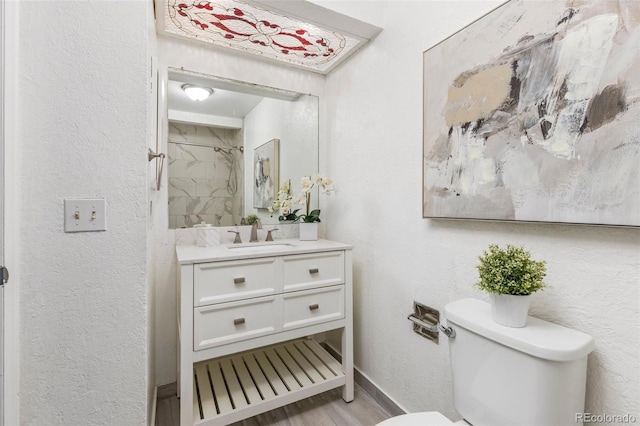 8260 Washington St Unit 78, Denver, CO 80229 - bathroom featuring vanity, a shower, wood finished floors, and a textured wall