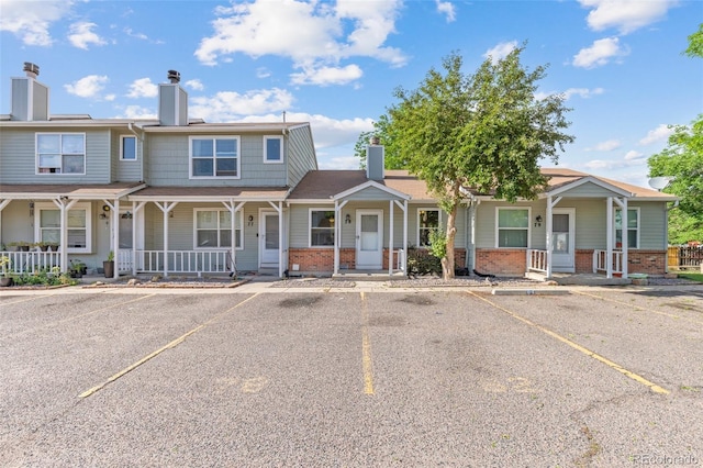 8260 Washington St Unit 78, Denver, CO 80229 - multi unit property with brick siding, covered porch, uncovered parking, and a chimney