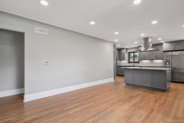 10595 E 23rd Ave, Aurora, CO 80010 - kitchen with stainless steel refrigerator with ice dispenser, island exhaust hood, gray cabinets, a kitchen island, and decorative backsplash