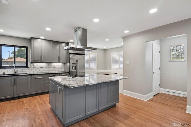 10595 E 23rd Ave, Aurora, CO 80010 - kitchen featuring gray cabinets, stainless steel fridge, island exhaust hood, a center island, and light wood-style floors