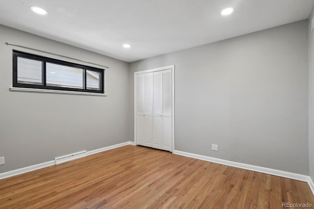 10595 E 23rd Ave, Aurora, CO 80010 - unfurnished bedroom with baseboard heating, light wood-type flooring, a closet, and recessed lighting