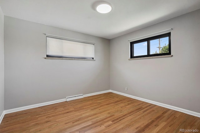 10595 E 23rd Ave, Aurora, CO 80010 - spare room featuring wood finished floors and a baseboard heating unit