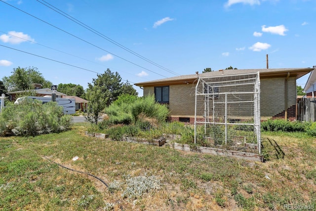 10595 E 23rd Ave, Aurora, CO 80010 - back of house with brick siding and a vegetable garden