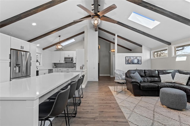 9630 N Surrey Dr, Castle Rock, CO 80108 - living room with a skylight, ceiling fan, recessed lighting, wood finished floors, and baseboards