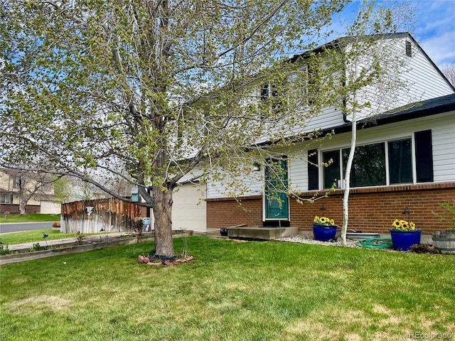 exterior space featuring a garage, a front lawn, and brick siding