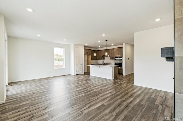 unfurnished living room with sink and dark hardwood / wood-style flooring