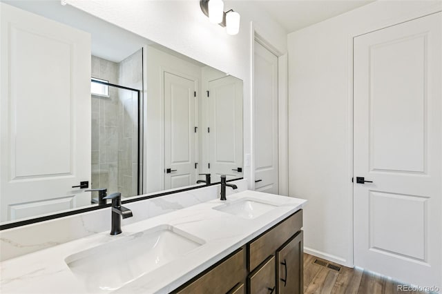 bathroom featuring vanity, an enclosed shower, and hardwood / wood-style floors