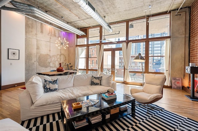 living room with expansive windows, a high ceiling, wood finished floors, and baseboards