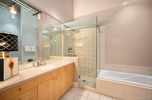 full bath with tile patterned flooring, a garden tub, a shower stall, and vanity