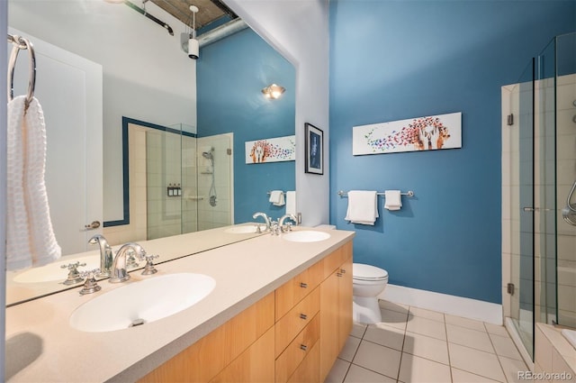 full bathroom featuring double vanity, tiled shower, a sink, and tile patterned floors