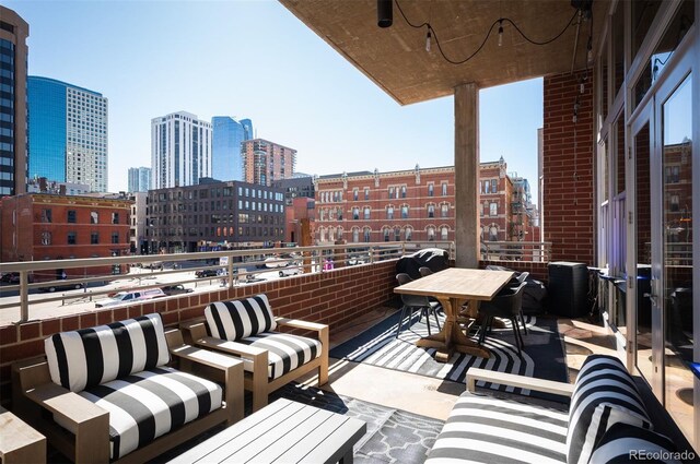 balcony with outdoor lounge area and a city view