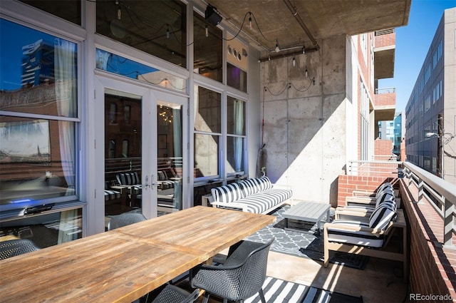 view of patio / terrace featuring outdoor dining space, french doors, and a balcony