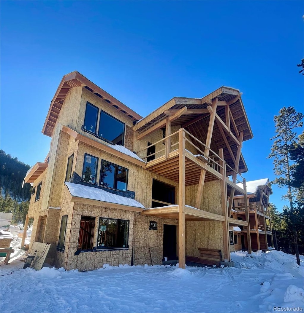 snow covered property with a balcony