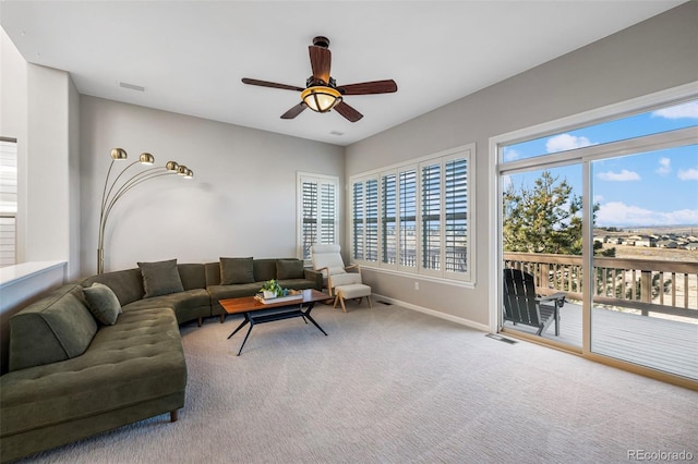 carpeted living area with visible vents, a ceiling fan, and baseboards