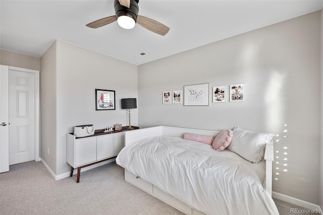 bedroom with a ceiling fan, light carpet, visible vents, and baseboards