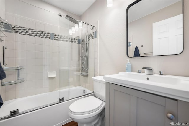 full bathroom featuring toilet, shower / bath combination with glass door, and vanity