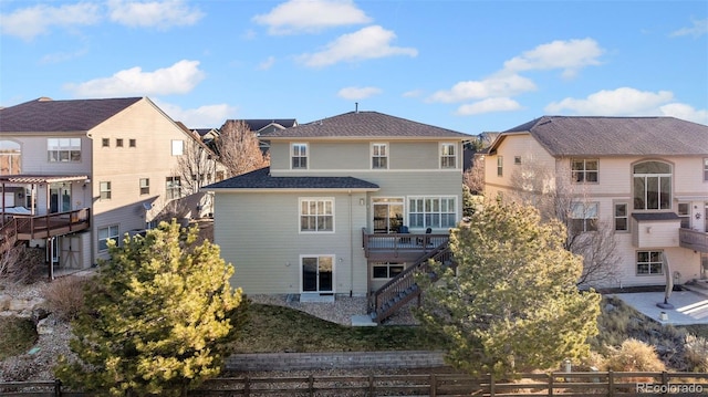 back of property featuring stairs, fence, and a residential view