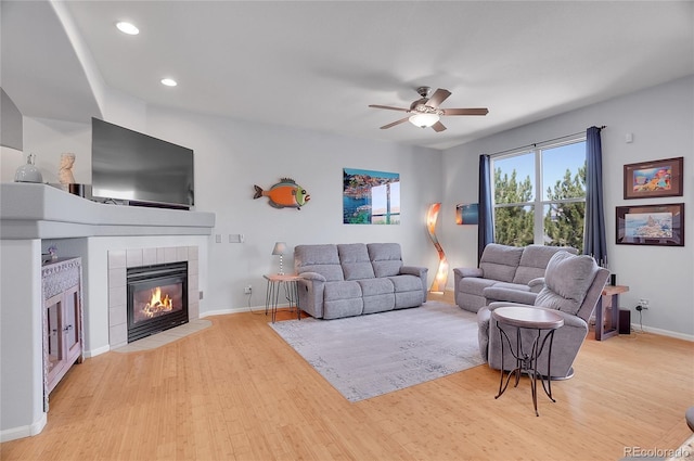 living room featuring baseboards, ceiling fan, wood finished floors, a fireplace, and recessed lighting