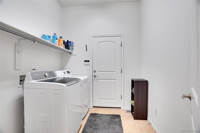 washroom featuring independent washer and dryer and light tile patterned floors