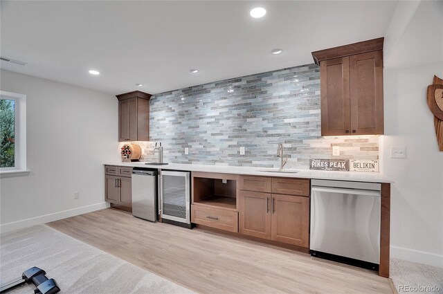 kitchen featuring tasteful backsplash, wine cooler, stainless steel appliances, sink, and light hardwood / wood-style floors