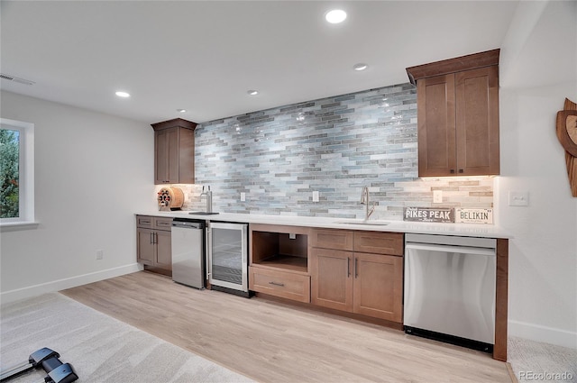 kitchen with beverage cooler, visible vents, dishwasher, backsplash, and a sink