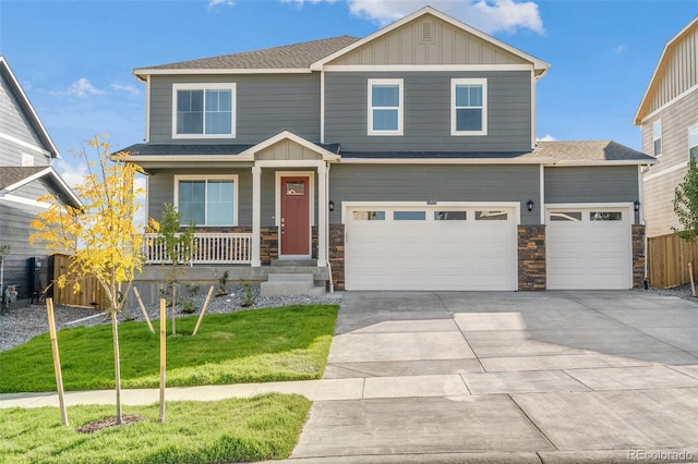 craftsman-style house with covered porch, a garage, and a front yard