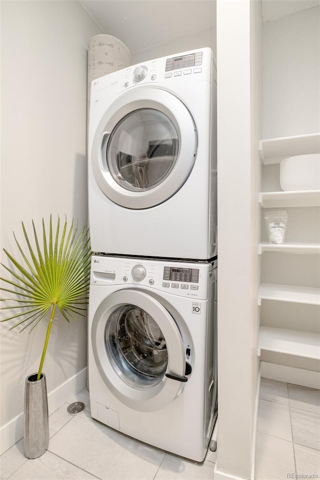 washroom with stacked washer and dryer and light tile patterned flooring