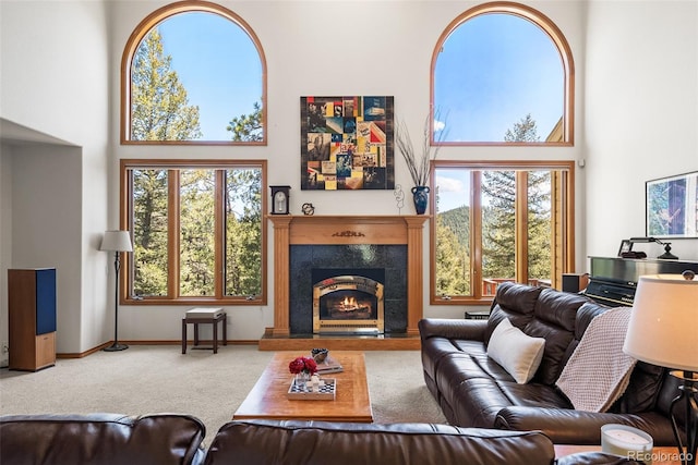 6252 King Dr, Evergreen, CO 80439 - carpeted living area with a high ceiling, healthy amount of natural light, a lit fireplace, and baseboards