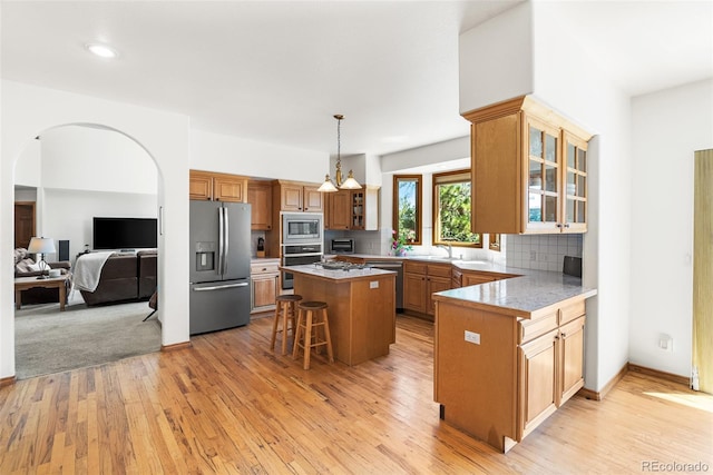 6252 King Dr, Evergreen, CO 80439 - kitchen featuring appliances with stainless steel finishes, a kitchen bar, glass insert cabinets, light wood finished floors, and recessed lighting